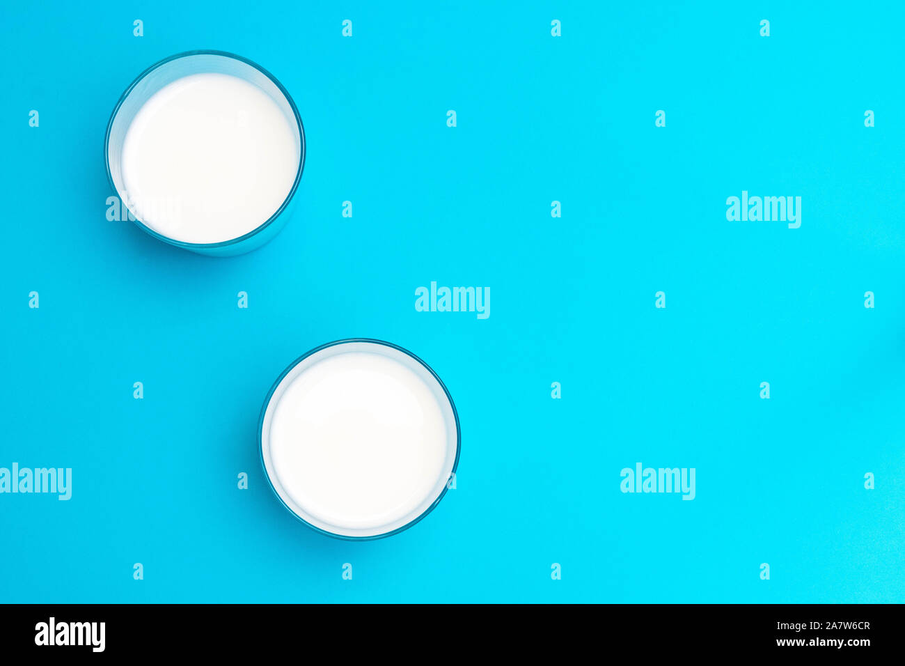 Two glasses of ayran (kefir) yogurt-based beverage with salt and water on blue background. Stock Photo