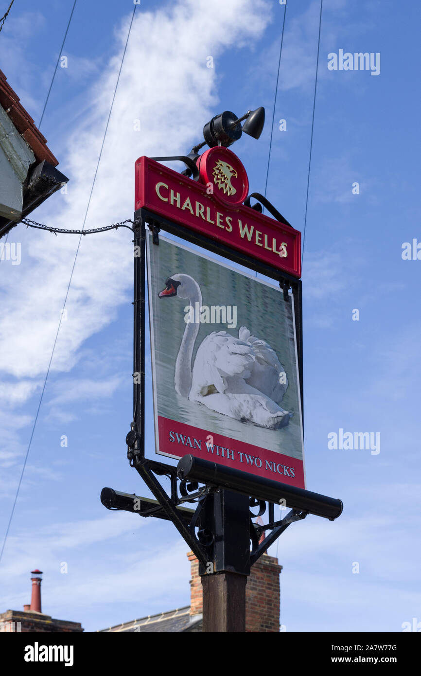 Pub sign for the Swan With Two Nicks, a traditional pub in the village of Sharnbrook, Bedfordshire, UK; part of the Charles Wells Brewery chain. Stock Photo