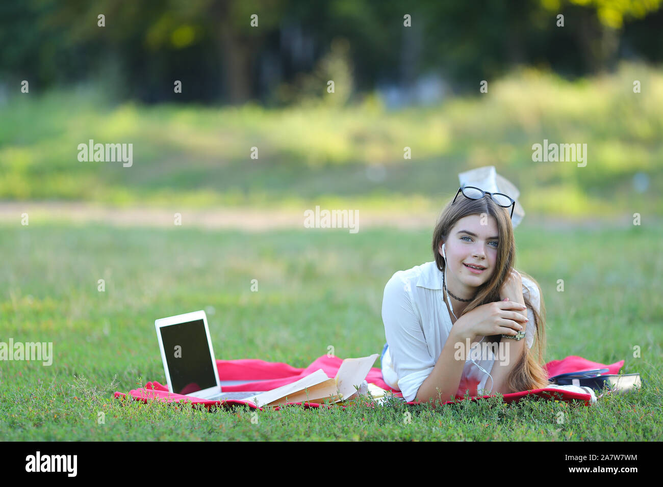 young girl lying on the grass in the park and works at a laptop Stock ...