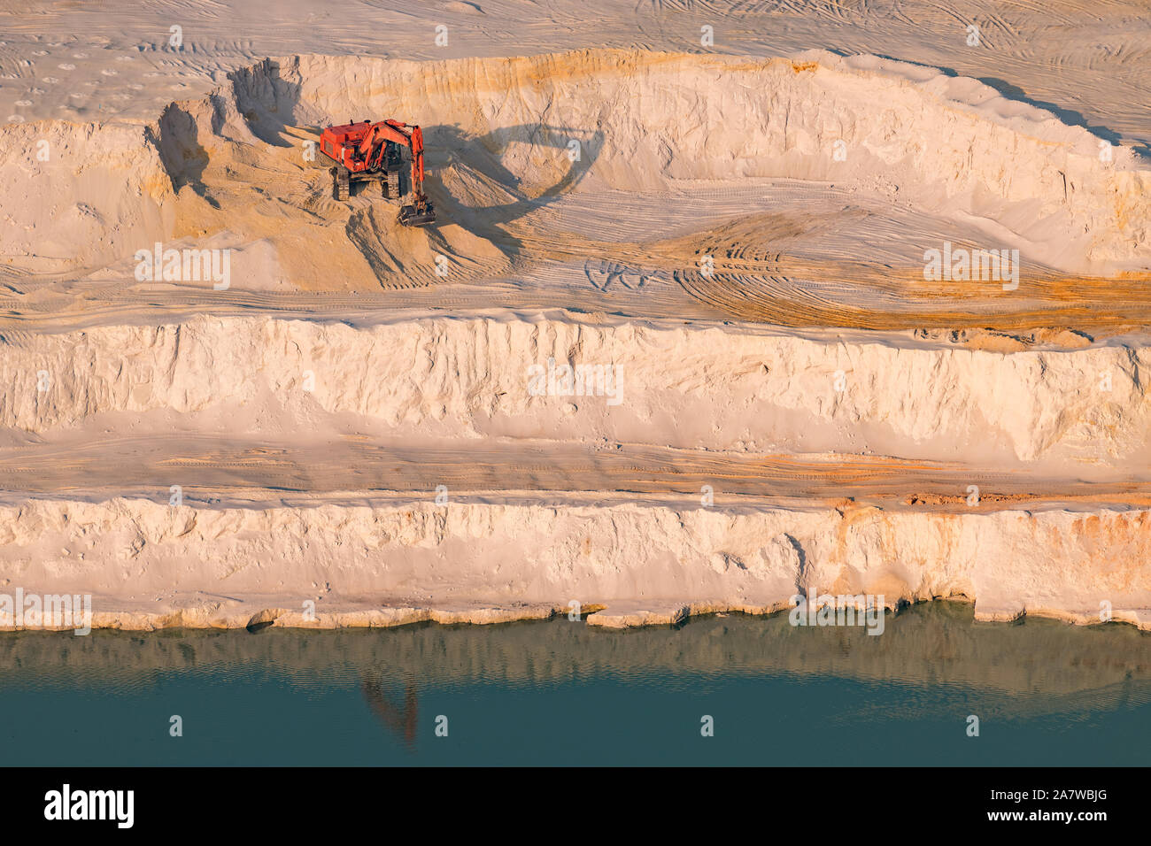Excavator at work in a glass sand quarry on aerial photo Stock Photo