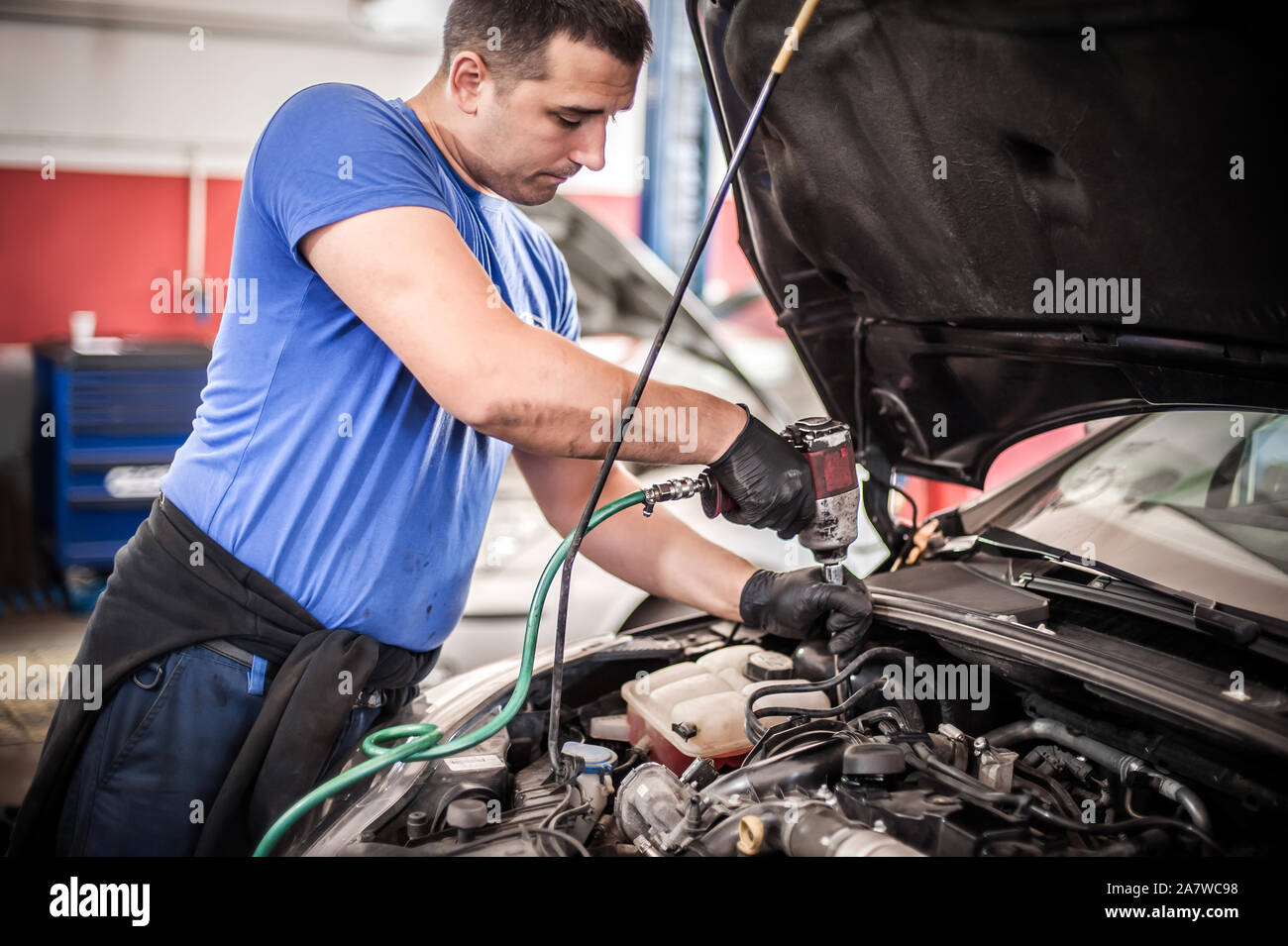 Car master mechanic repairer checking, testing and changing spark plugs