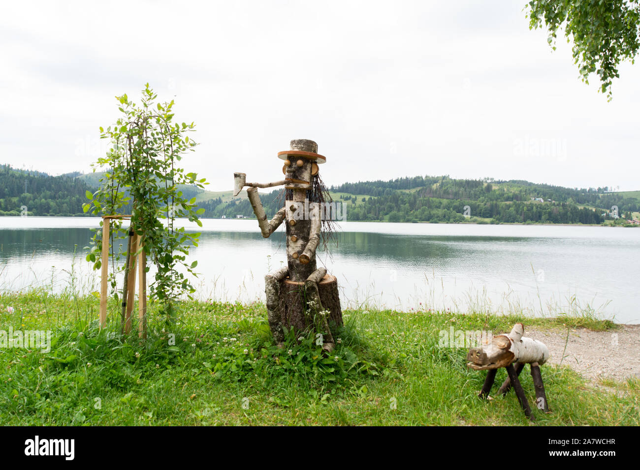 Dedinky, Roznava, Kosice region / Slovakia -  statue of a character smoking a pipe accompanied by his pet, on a lake Stock Photo