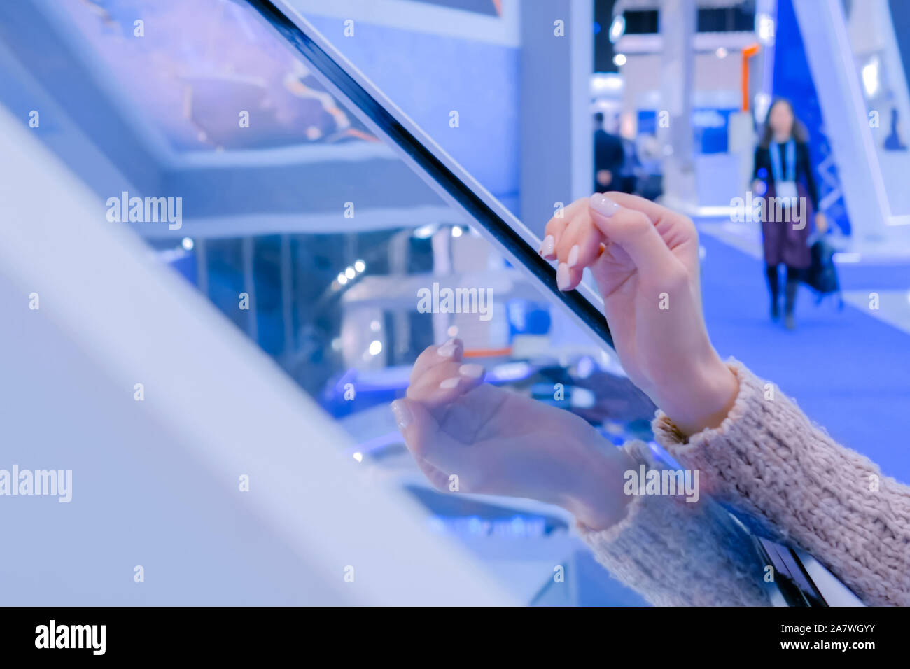 Woman using interactive touchscreen display at technology exhibition Stock Photo