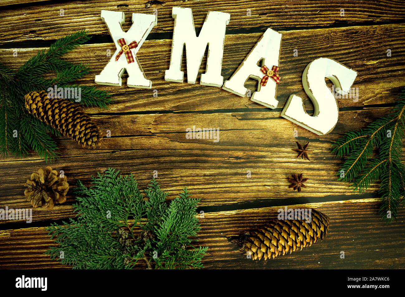 wooden brown background with white christmas text and natural decoration . Stock Photo