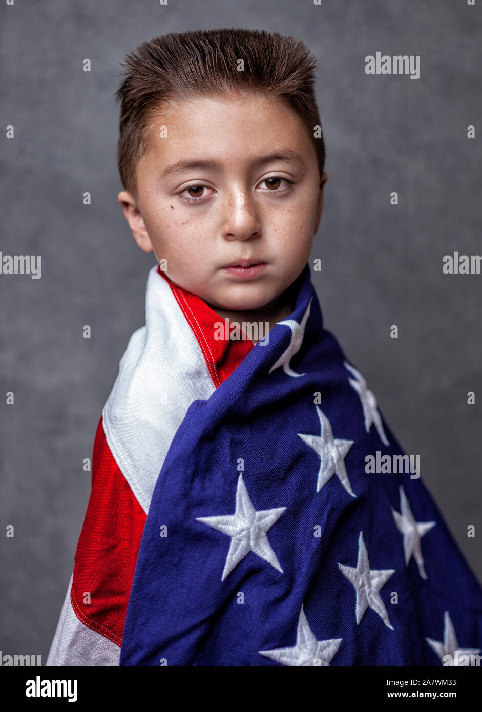 Asian Caucasian mixed race little boy with brunette flat top haircut  wrapped in American flag posed against a gray backdrop Stock Photo - Alamy