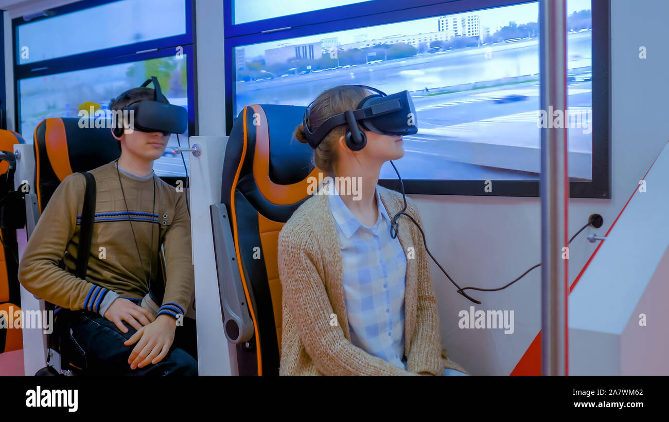 Young woman and man using virtual reality glasses and looking around