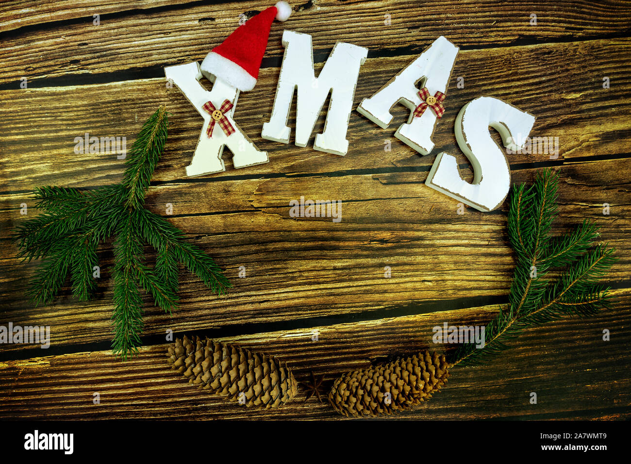 wooden brown background with white christmas text and natural decoration . Stock Photo