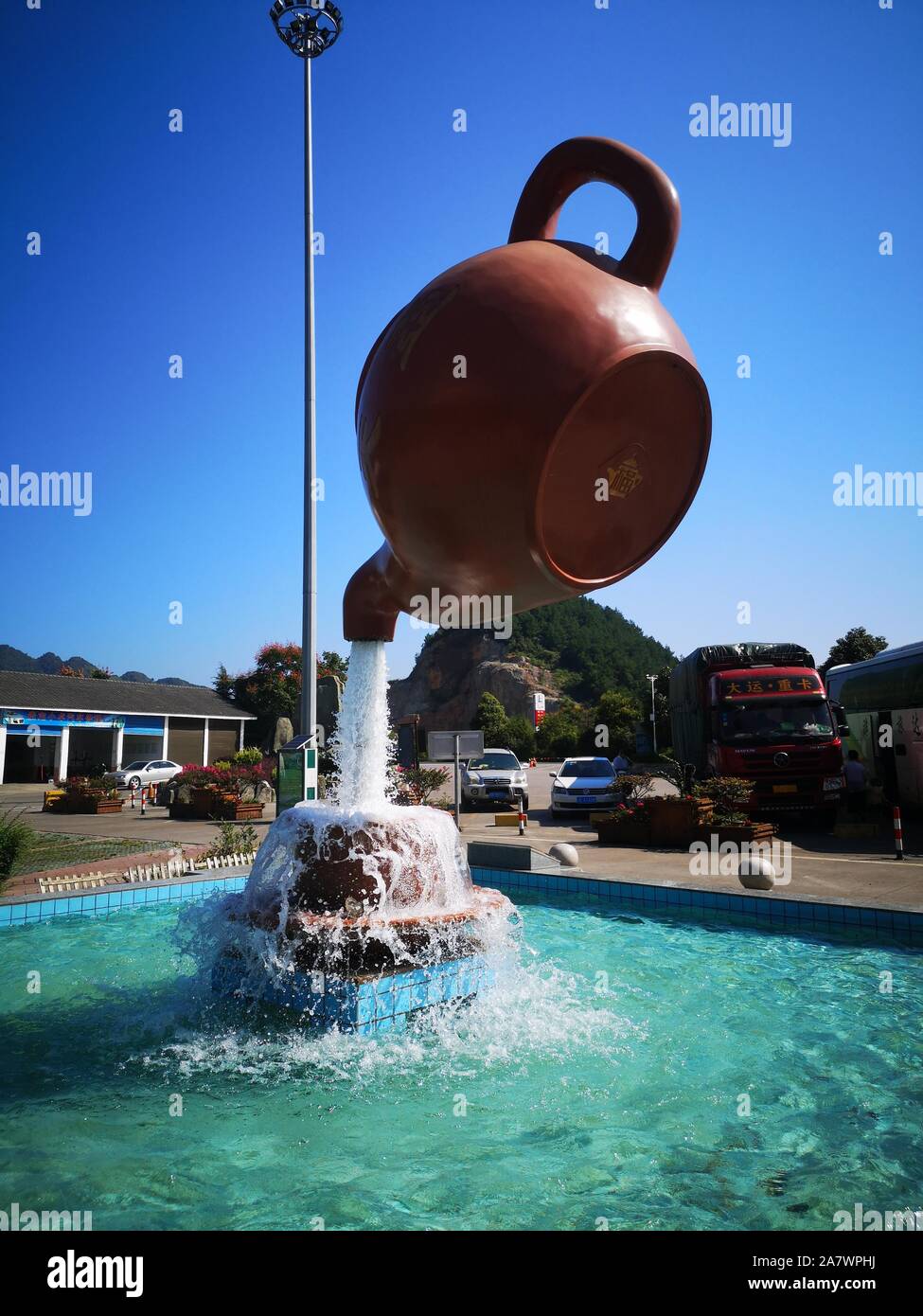 A giant floating teapot and teacup water fountain is displayed at an expressway service area in