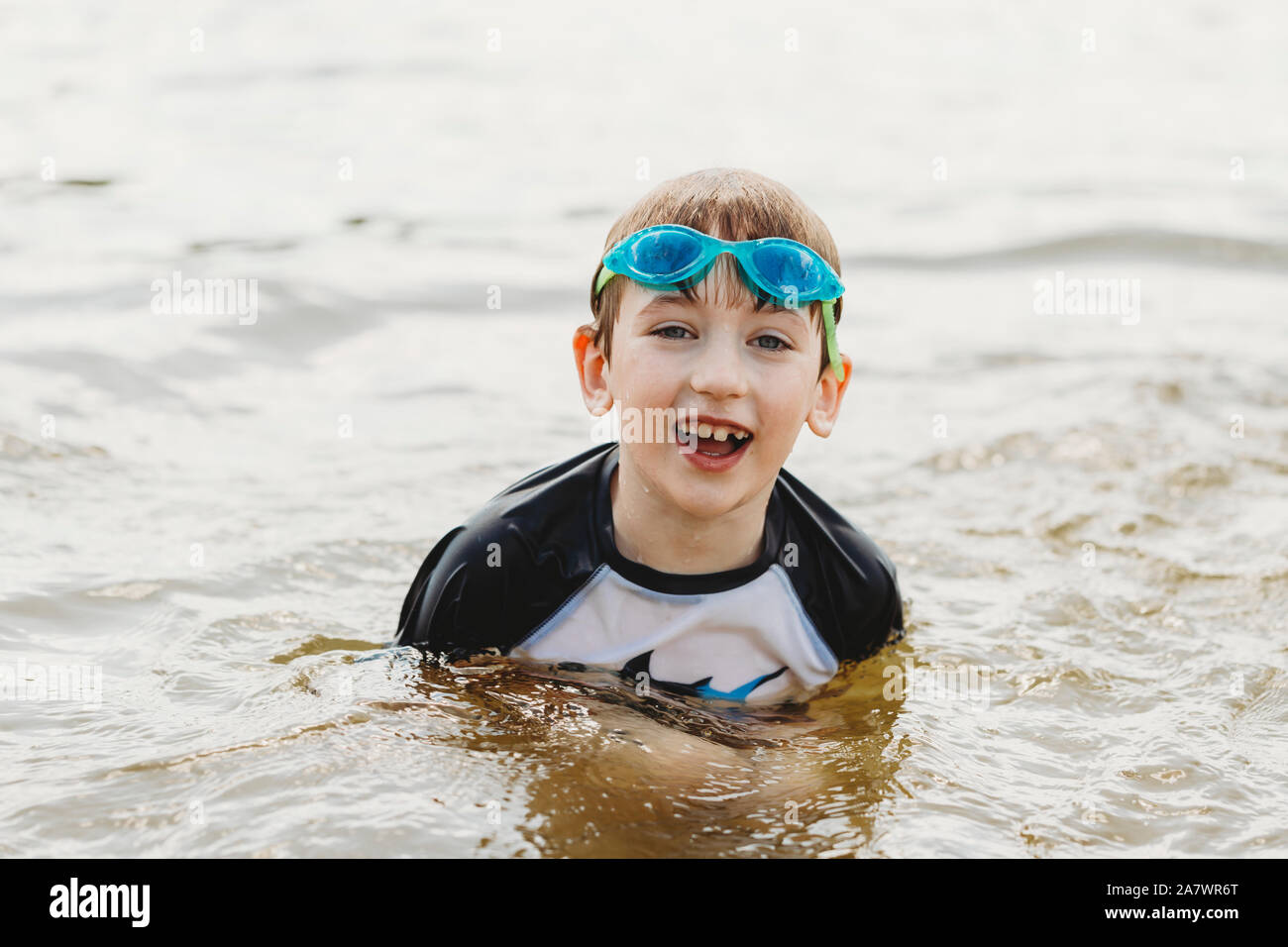 Boy wearing goggles coming out of the water Stock Photo Alamy