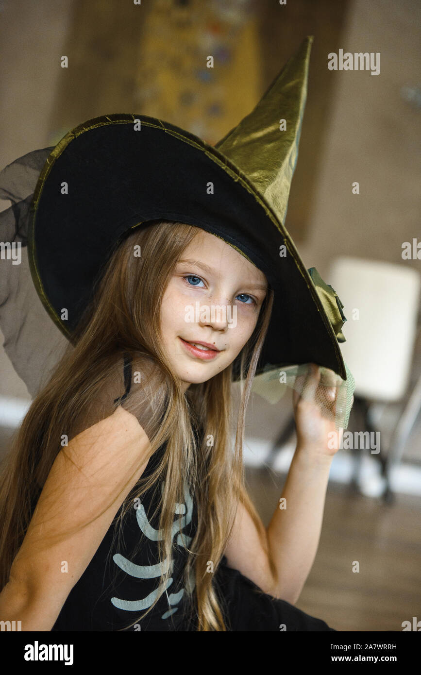 Smiling Teenage Girl in Hat Dressed for Halloween in Witch Costume Stock Photo