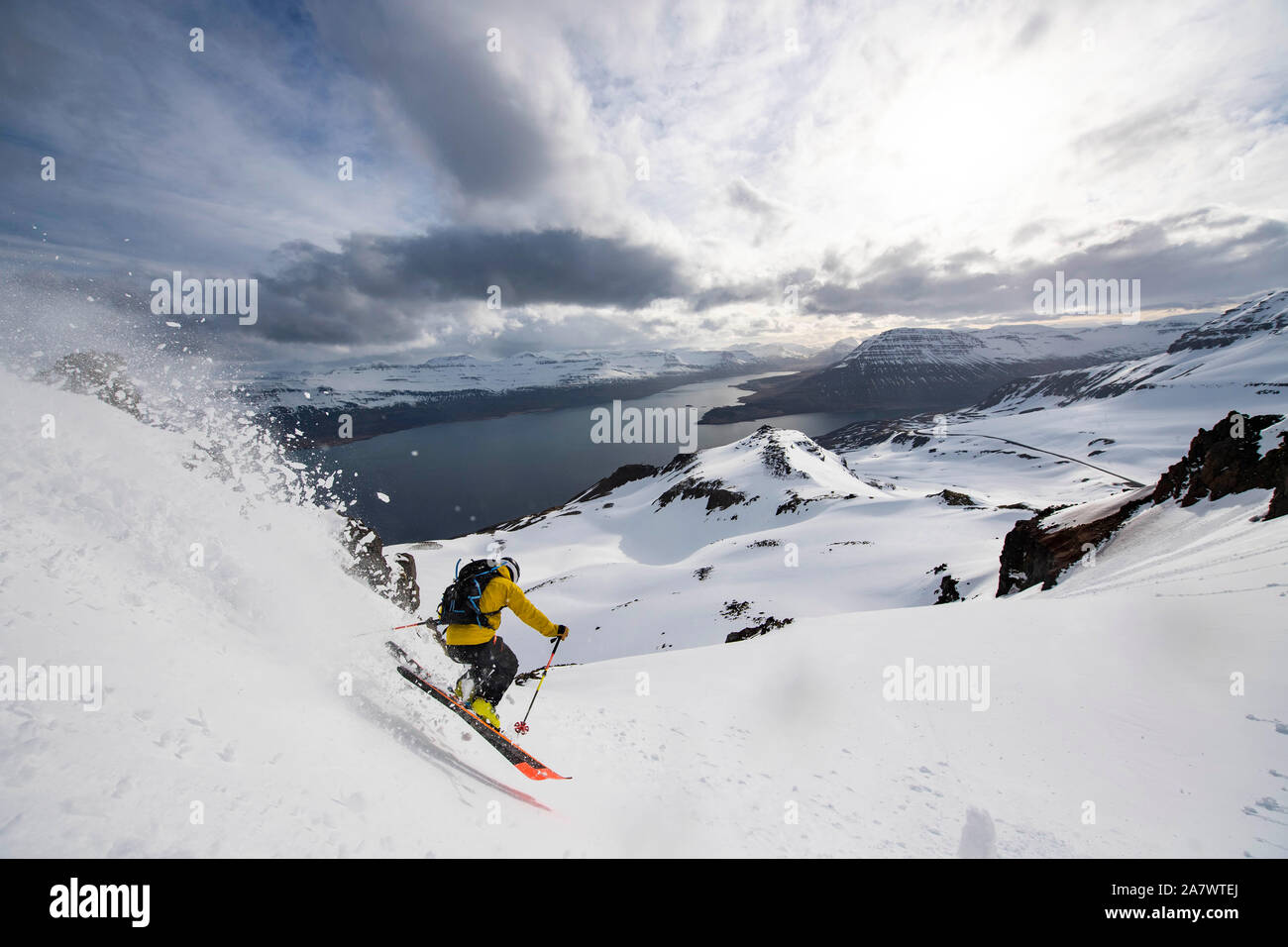 A man backcountry skiing at sunset to the ocean in Iceland Stock ...