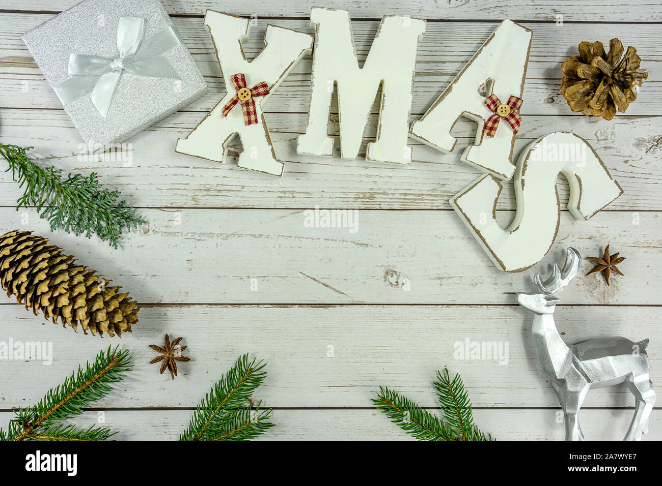 Christmas frame background flat lay on white wood with gift box xmas text and other natural decoration . Stock Photo