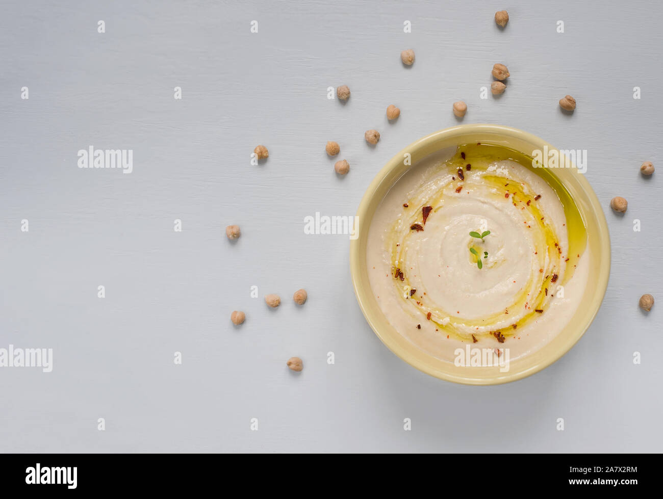 Homemade hummus bowl, decorated with  chickpeas and olive oil over background. Top View.Vegetarian healthy food concept. Stock Photo