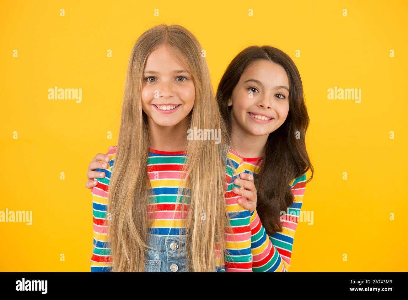 Children are the future. Happy children with long hair yellow background. Small children in casual style. Little children cute smiling. International childrens day. Stock Photo