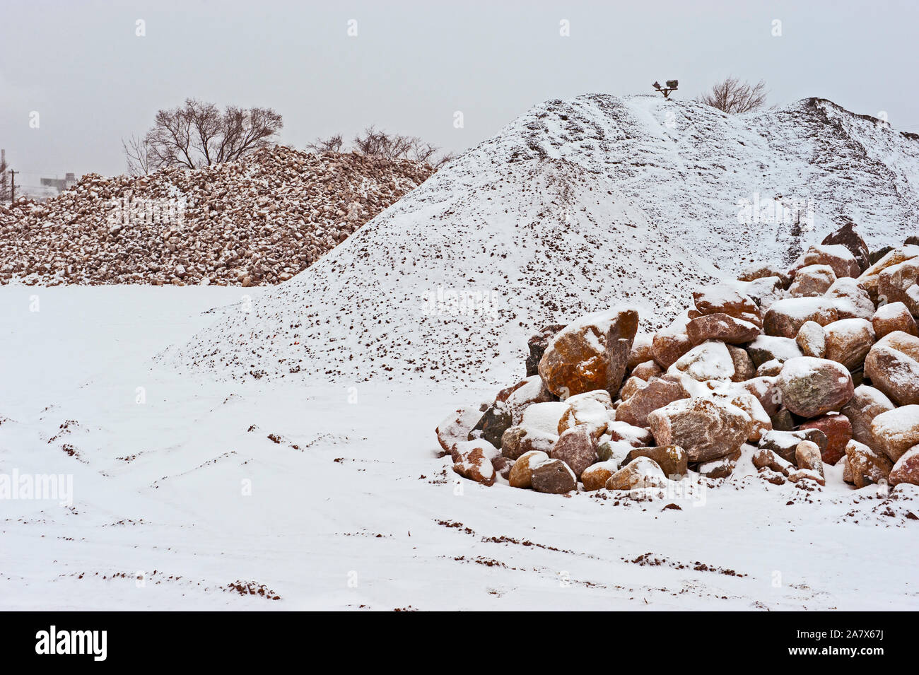 Rock and stone piles at a local road construction company in the winter ...