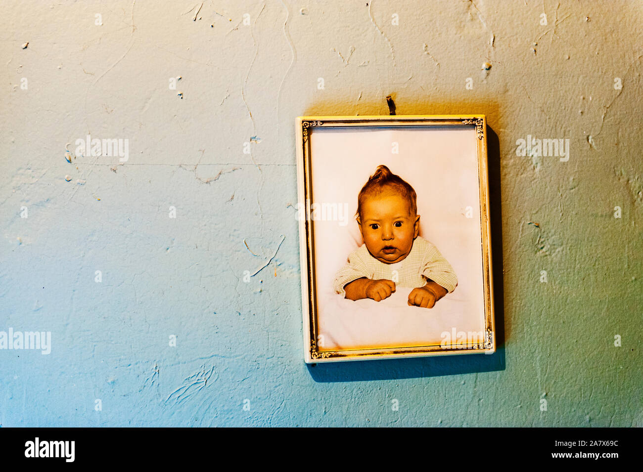 Framed baby picture from the 1950s hanging on the wall. Stock Photo