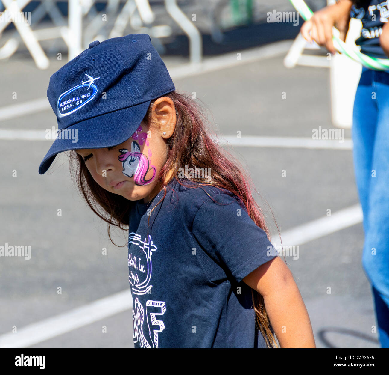 Anaheim, CA / USA - Nov 3, 2019: Pink and white face paint looks very cute on a pretty, long-haired girl. Stock Photo
