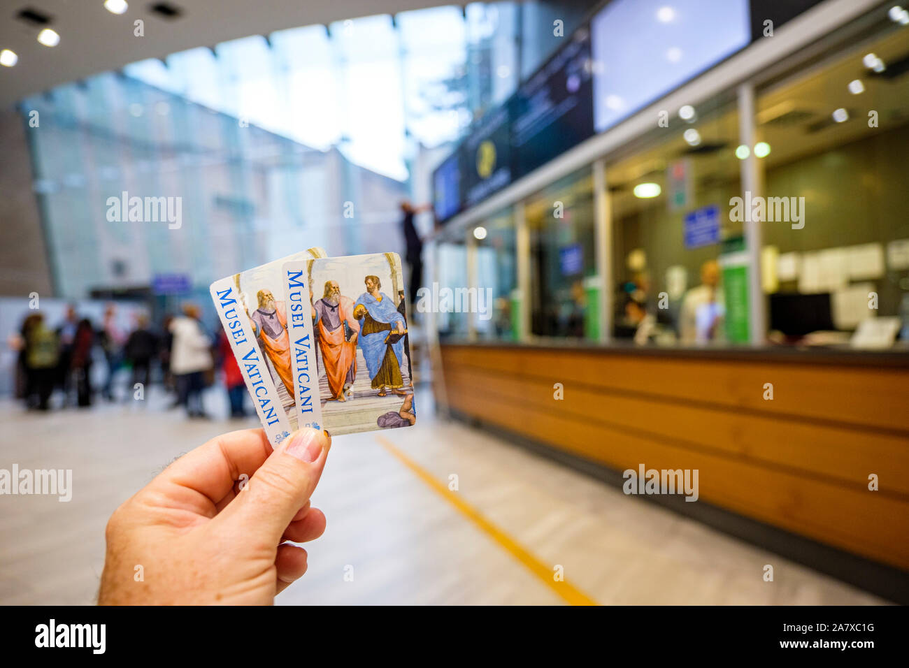 Visitor holding two admission tickets close to ticket counters/group tours area inside the Vatican Museums, Vatican Museum, Rome, Italy Stock Photo