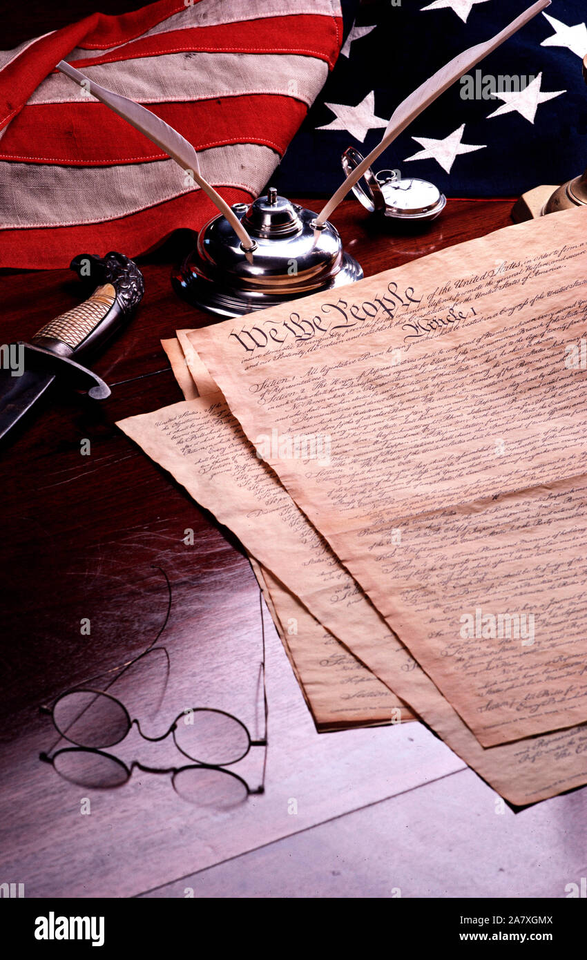 Still life of the Constitution of the United States of America with American flag, quill pen, inkwell, and antique specs Stock Photo