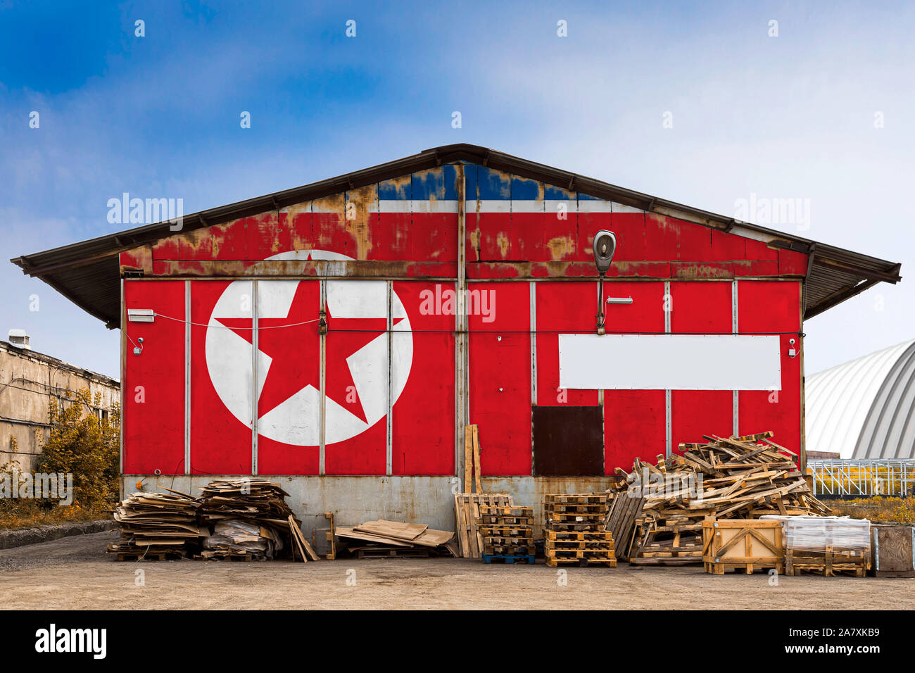 Close-up of the national flag of North Korea painted on the metal wall of a large warehouse the closed territory on a summer day. The concept of stora Stock Photo