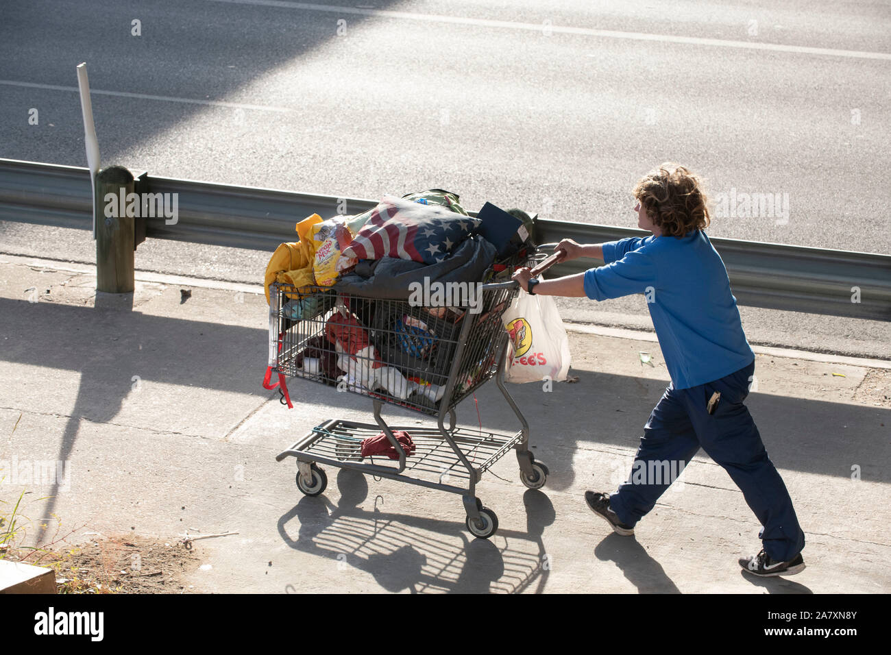 Homeless Texan leaves temporary encampment under highway overpass as state highway workers move in,  ordered by Texas Gov. Greg Abbott to clean up homeless areas in the public right-of-way. There are 17 identified sites scheduled for cleanup in the Austin area. Stock Photo