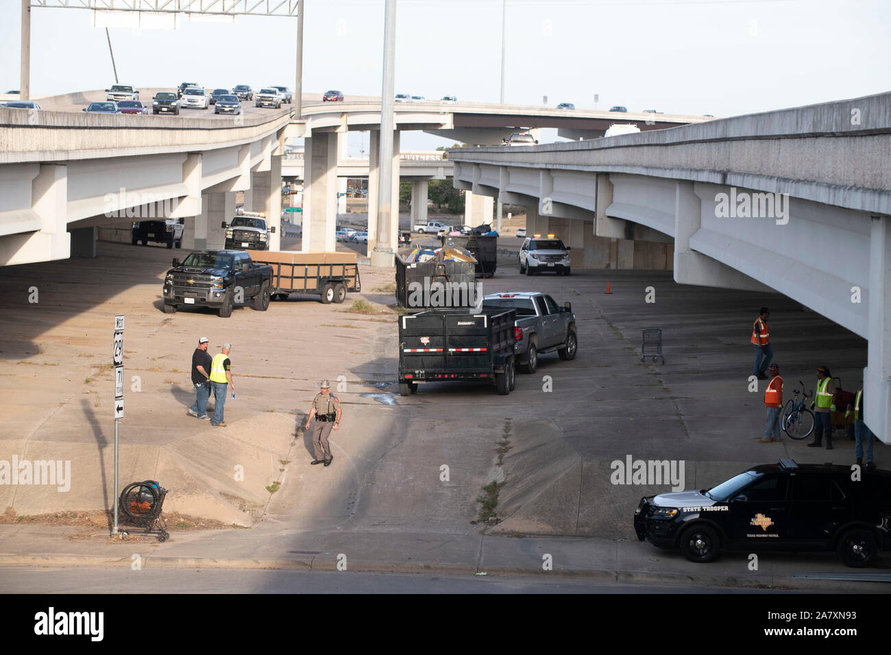 Workers from the Texas Highway Department finish cleaning up a homeless