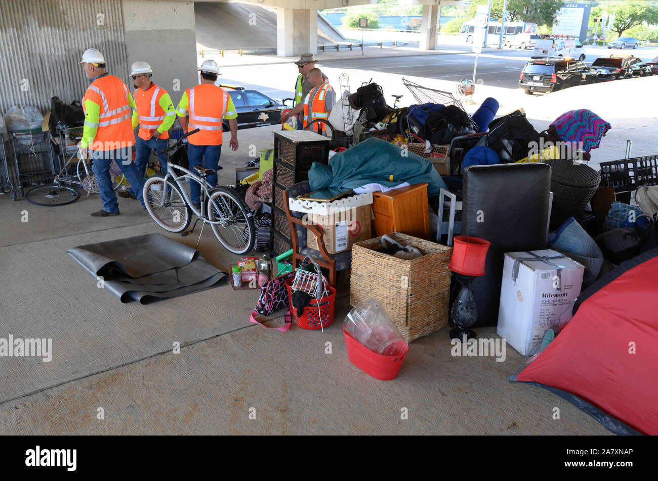 Texas Department of Transportation contractors clean up a homeless