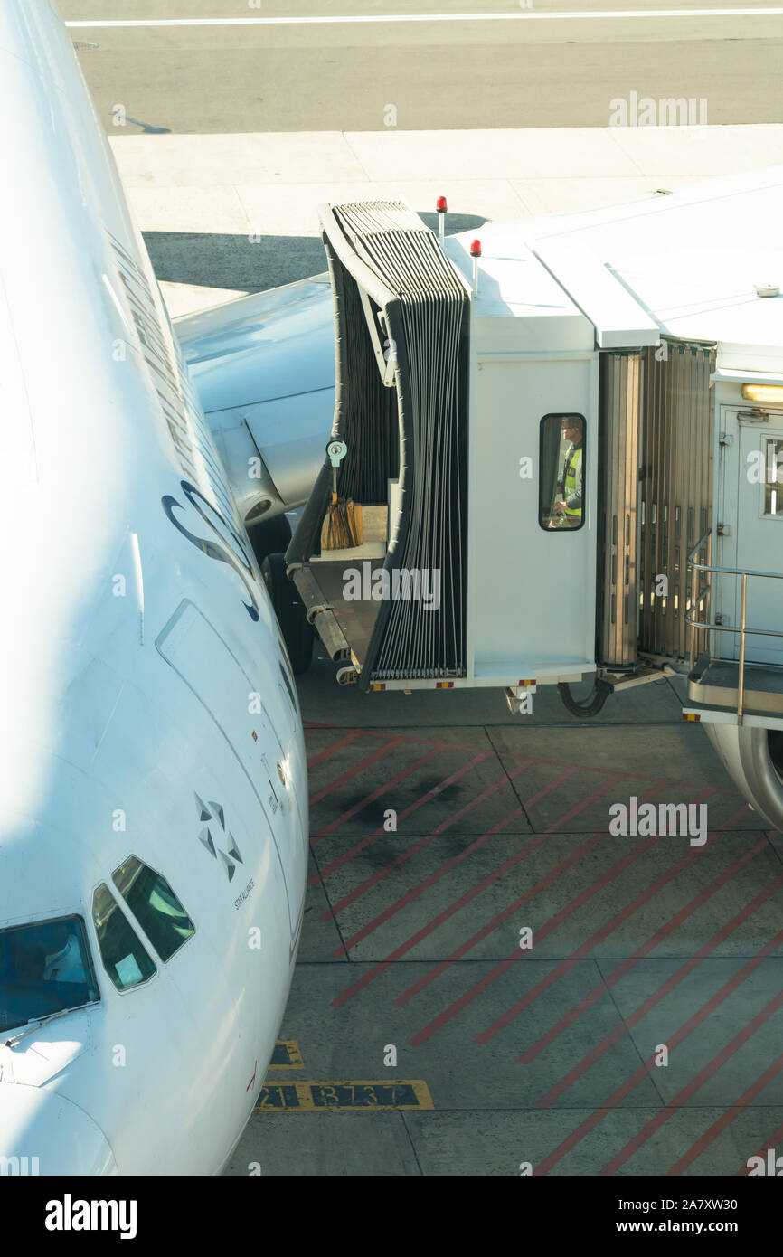 attaching a jet bridge, jetway, airgate, gangway, aerobridge, airbridge, air jetty, portal, sky bridge, finger, airtube, passenger boarding bridge Stock Photo