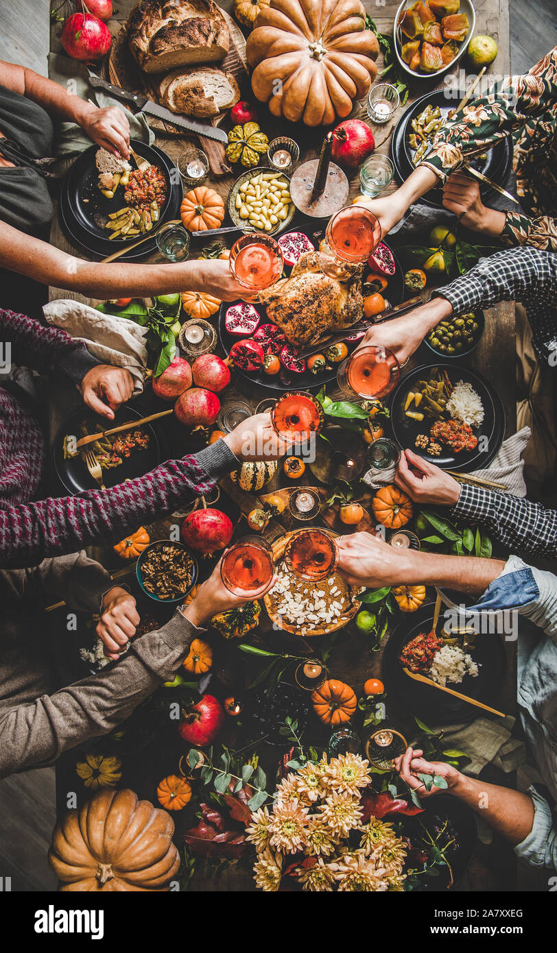 Family or friends celebrating Thanksgiving day clinking glasses with champagne Stock Photo