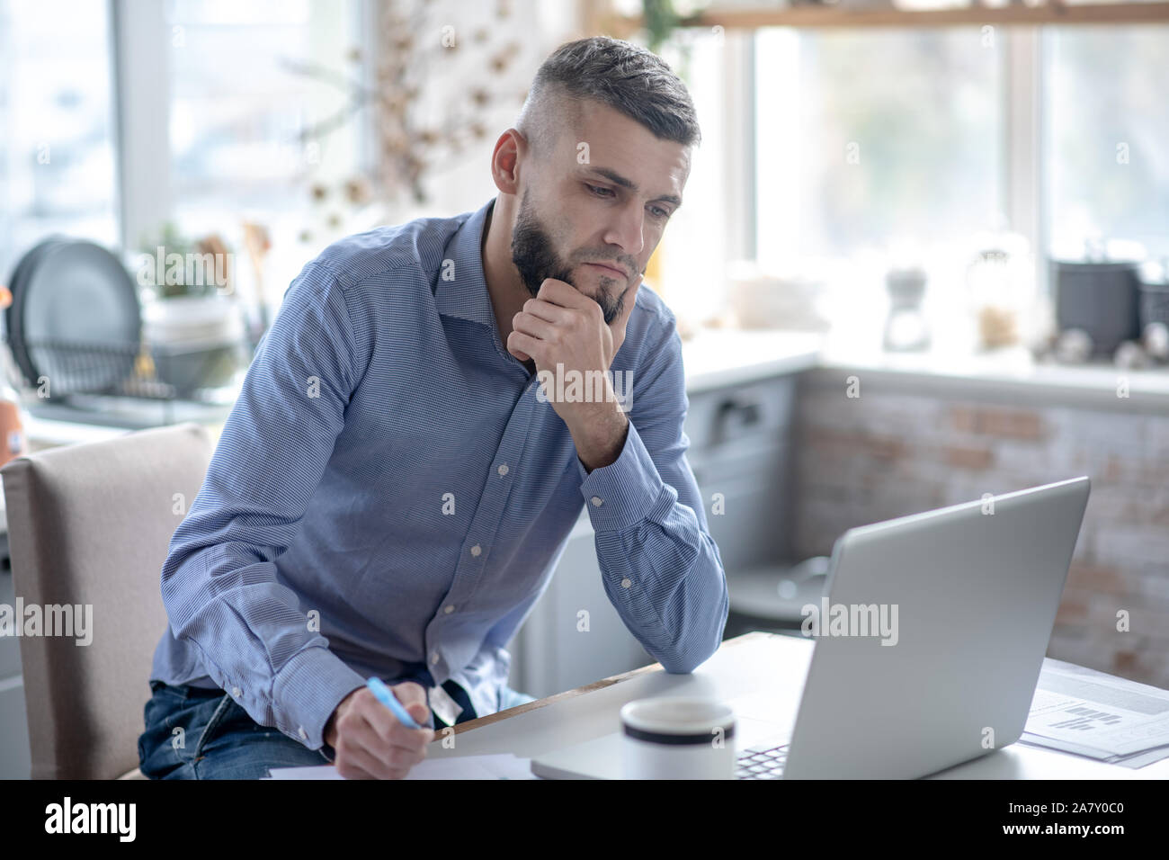 Businessman feeling concerned while preparing financial report Stock Photo
