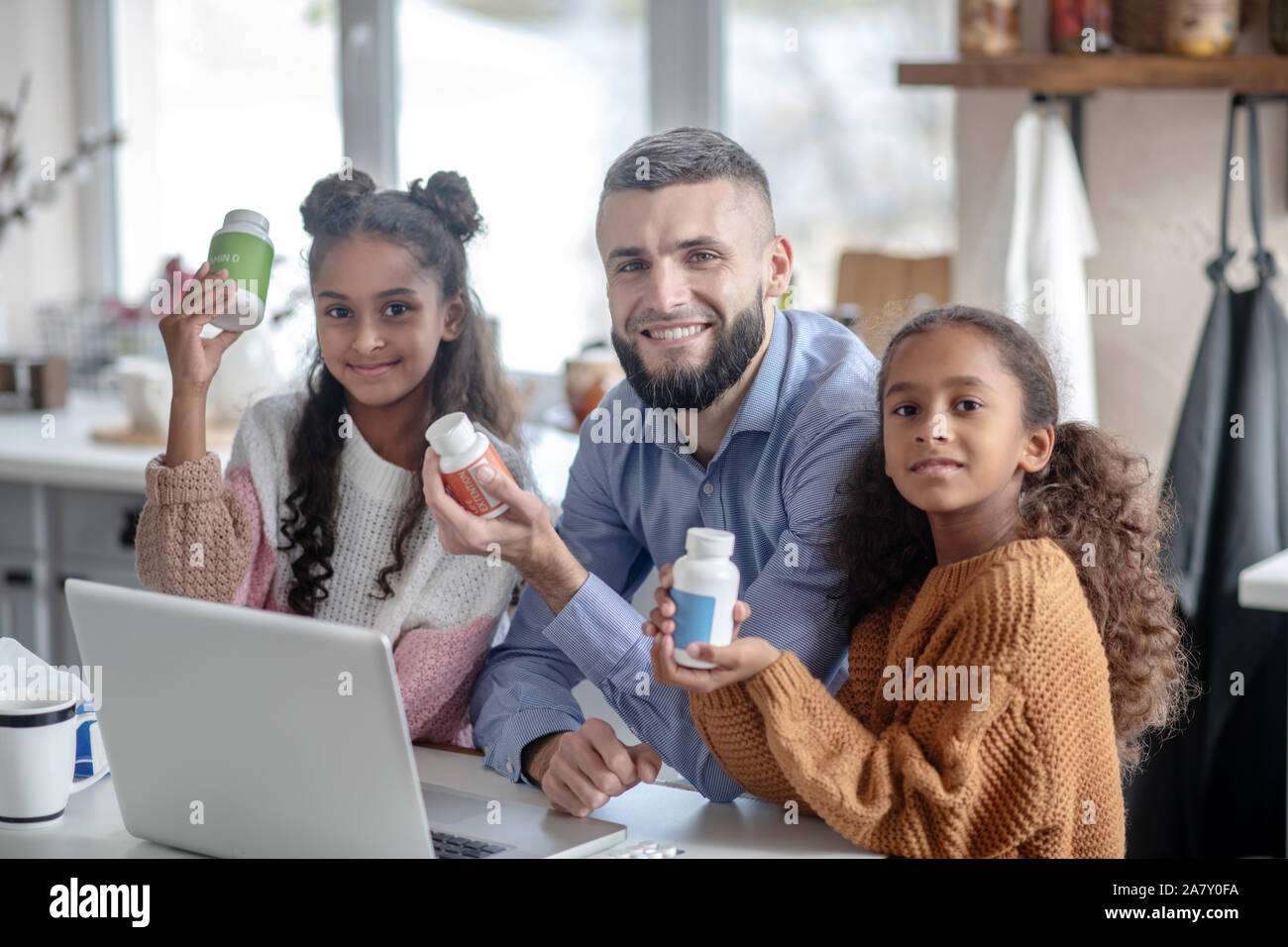 Father and girls holding vitamins while leading healthy lifestyle Stock Photo