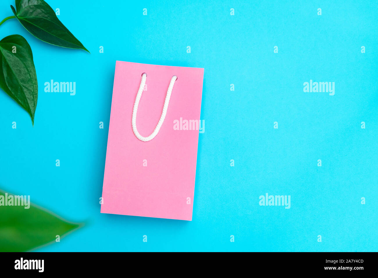 Shopping and sale concept. Pink paper bag on bright blue background ...
