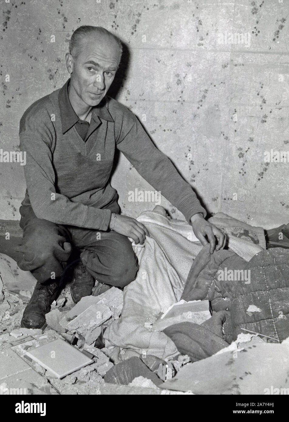 Bomb that hit PRO today aslo hurt some of the war correspondents, among whom was Ernie Pyle. He suffered a slight cut on the face and is here looking at his bed from which he had just left to watch the bombing when the roof fell on it Stock Photo