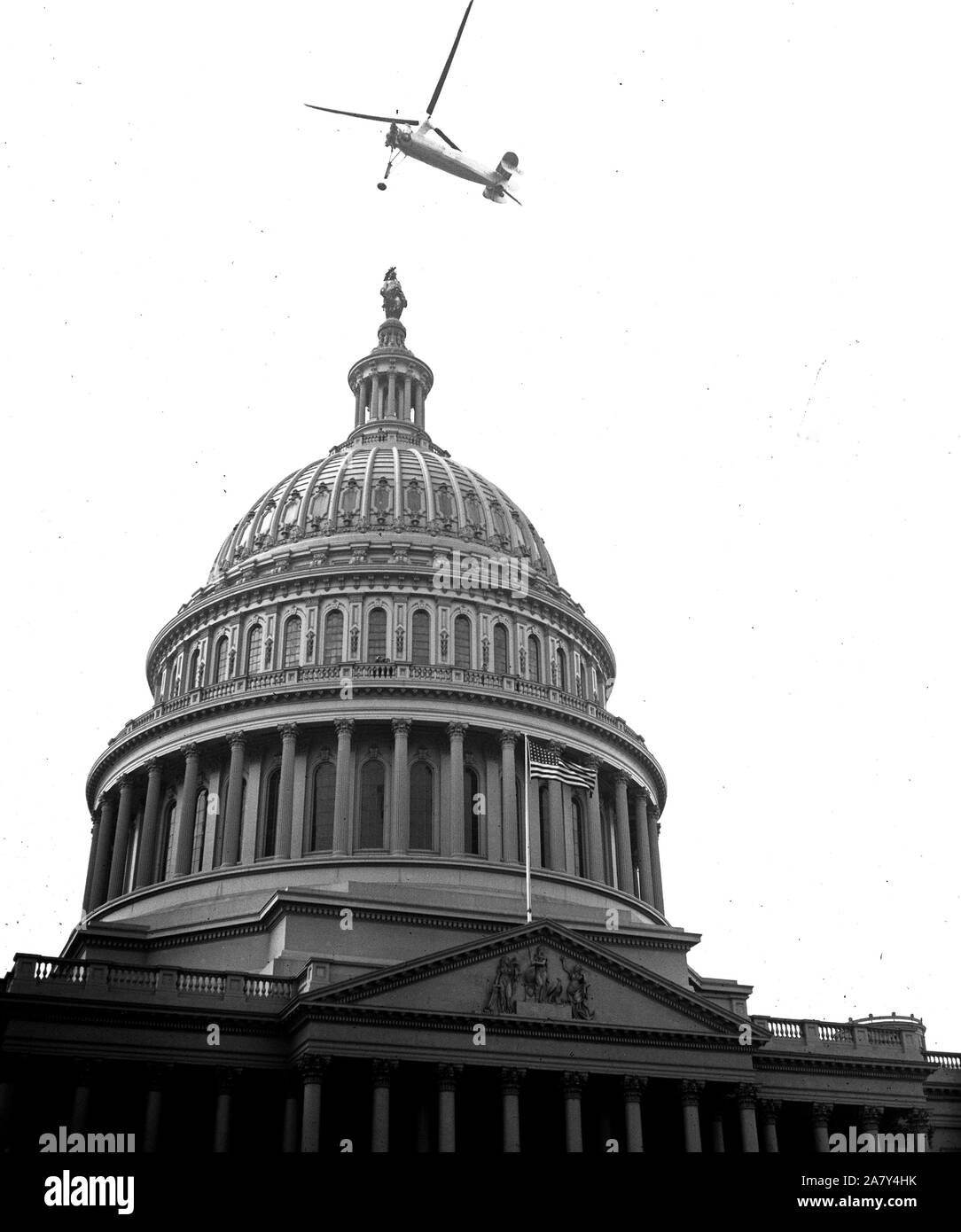 A helicopter type aircraft above the U.S. Capitol ca. 1936 Stock Photo