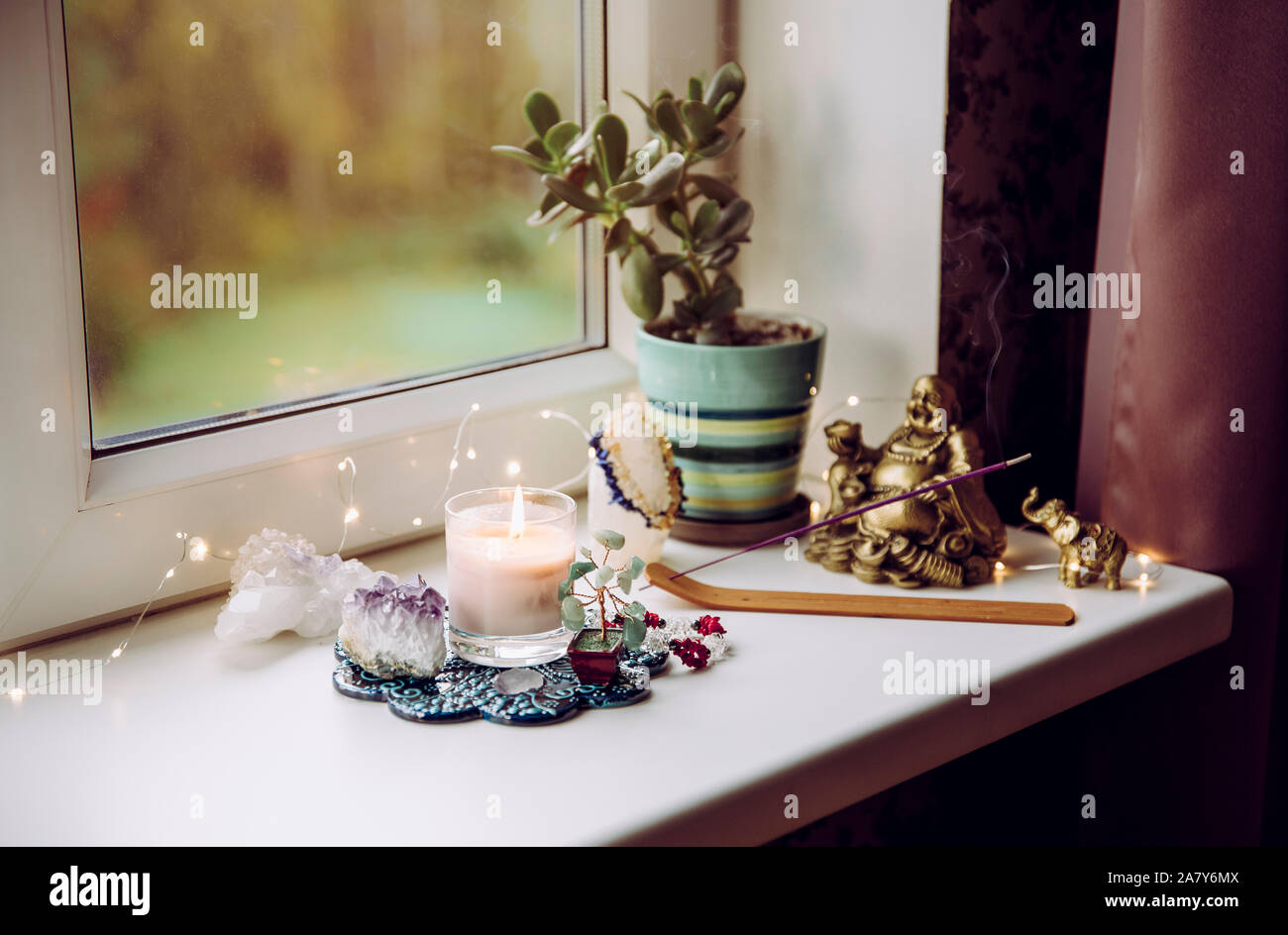 Feng Shui altar at home in living room or bed room. Attracting wealth and prosperity concept. Crystal clusters, wire tree with gemstones, golden smili Stock Photo