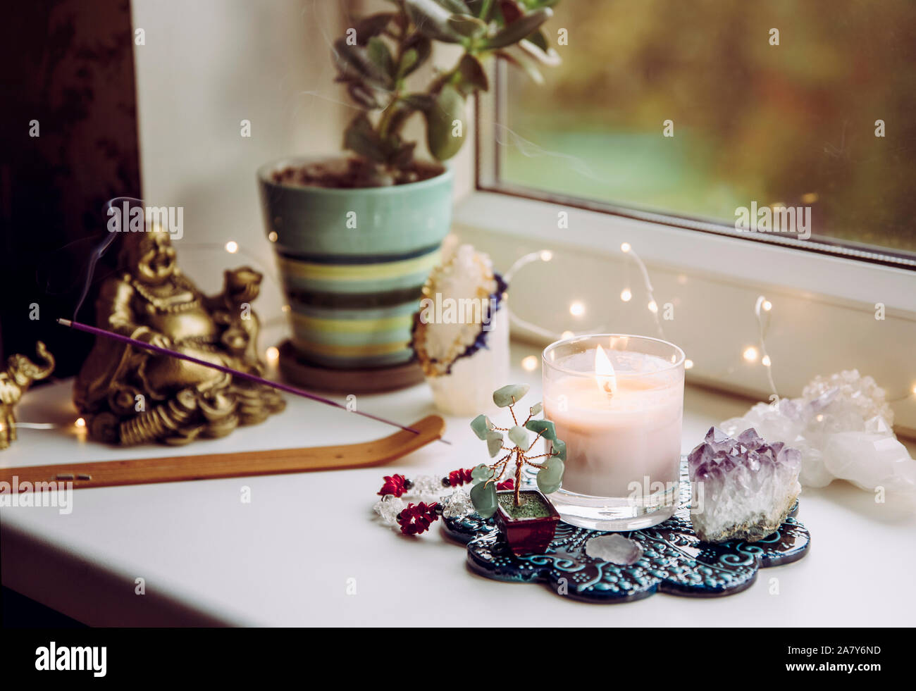 Feng Shui altar at home in living room or bed room. Attracting wealth and prosperity concept. Crystal clusters, wire tree with gemstones, golden smili Stock Photo