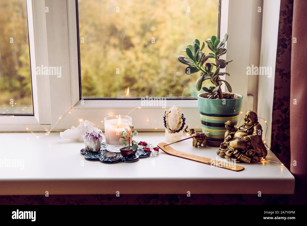 Feng Shui altar at home in living room or bed room. Attracting wealth and prosperity concept. Crystal clusters, wire tree with gemstones, golden smili Stock Photo