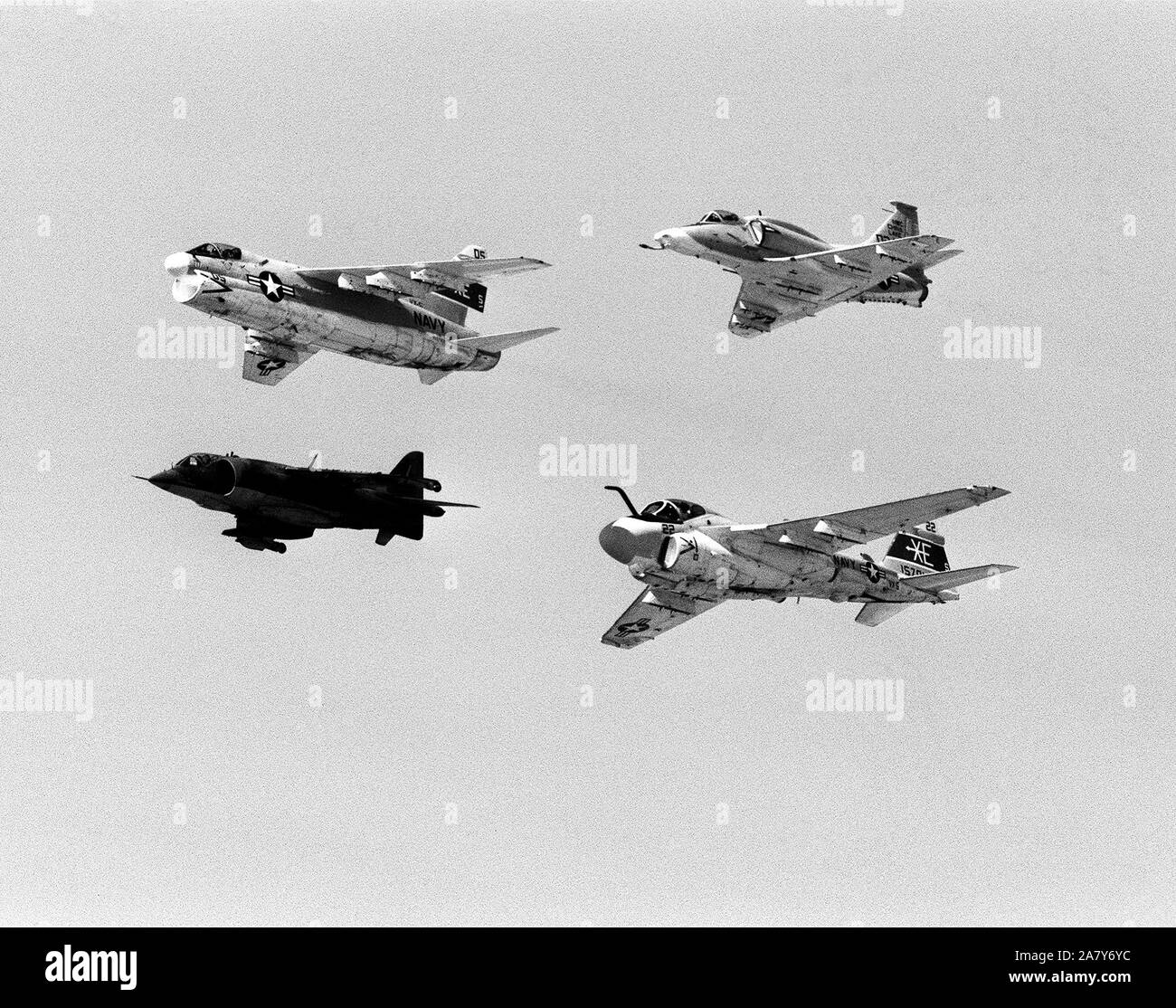 Ground-to-air view of four aircraft flying in formation during Test and Evaluation Squadron Five (VX-5) airshow.  The aircraft over Armitage Field, are (from left to right, clockwise) an A-7E Corsair II, an A-4M Skyhawk, and A-6E Intruder and an AV-8C Harrier. Stock Photo