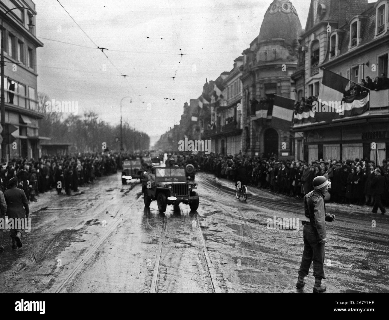 Happy crowds of Frenchmen greet convoys of the 28th Infantry Division going through the city of Colmar, France, after its liberation February 3, 1945 Stock Photo