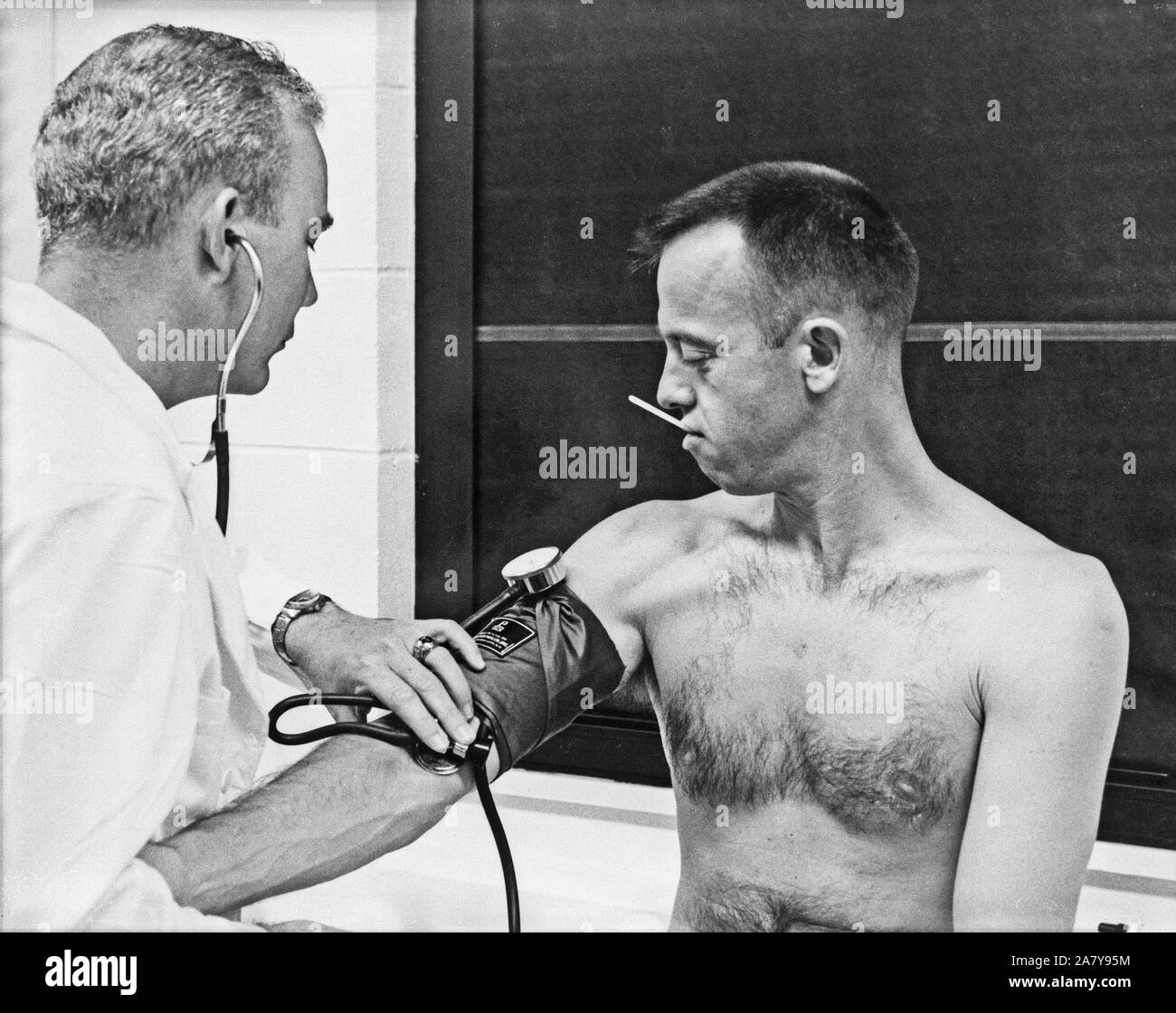 Astronaut Alan B. Shepard Jr. has his blood pressure and temperature checked prior to his Mercury-Redstone 3 (MR-3) mission, the first American manned spaceflight. Stock Photo