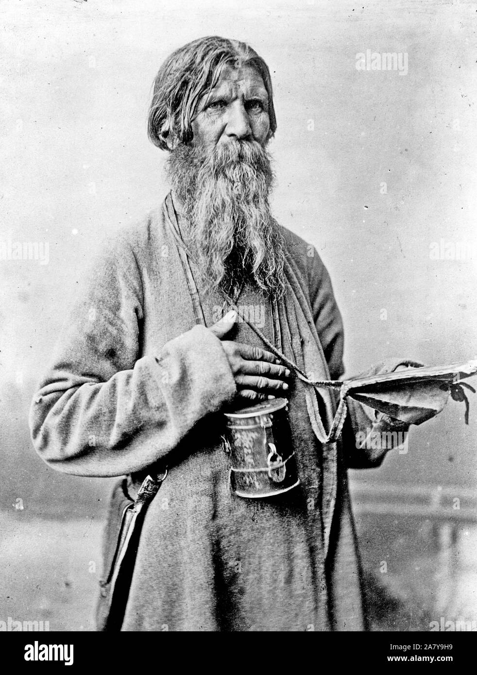 Bearded man, standing, three-quarter length, with box with slot to deposit money, Russia. 1880-1924 Stock Photo