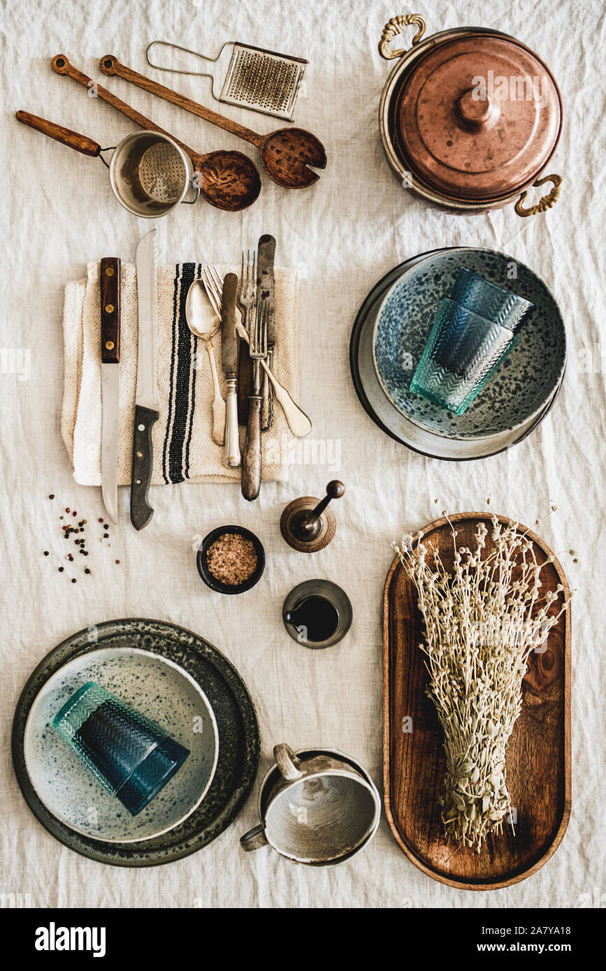 Various kitchen utensils and tablewear over linen tablecloth, vertical composition Stock Photo