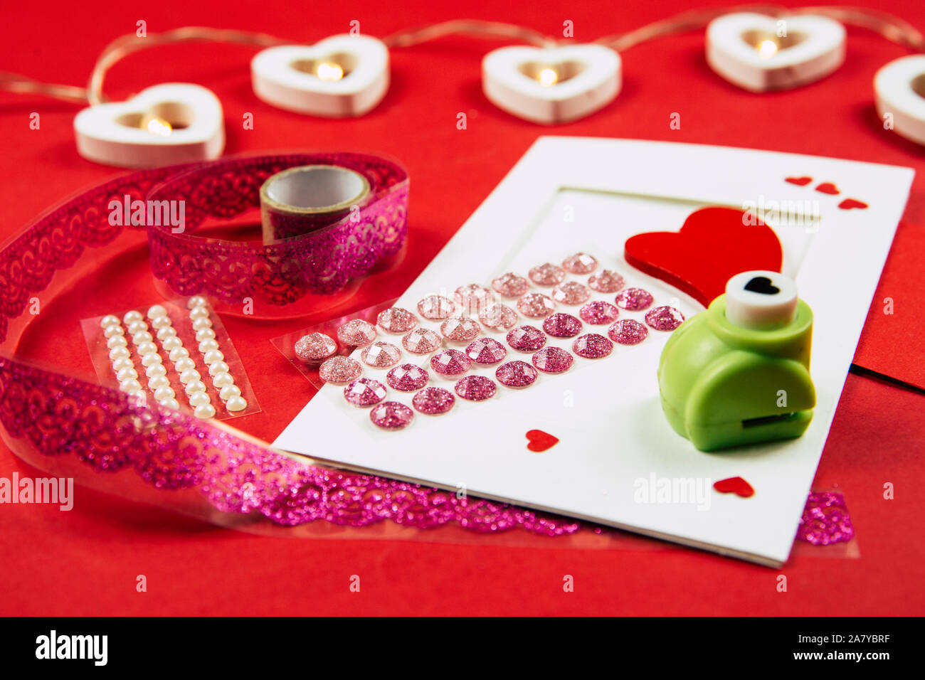 Making Greetings card concept. Various arts and crafts tools on table, red background. Stock Photo