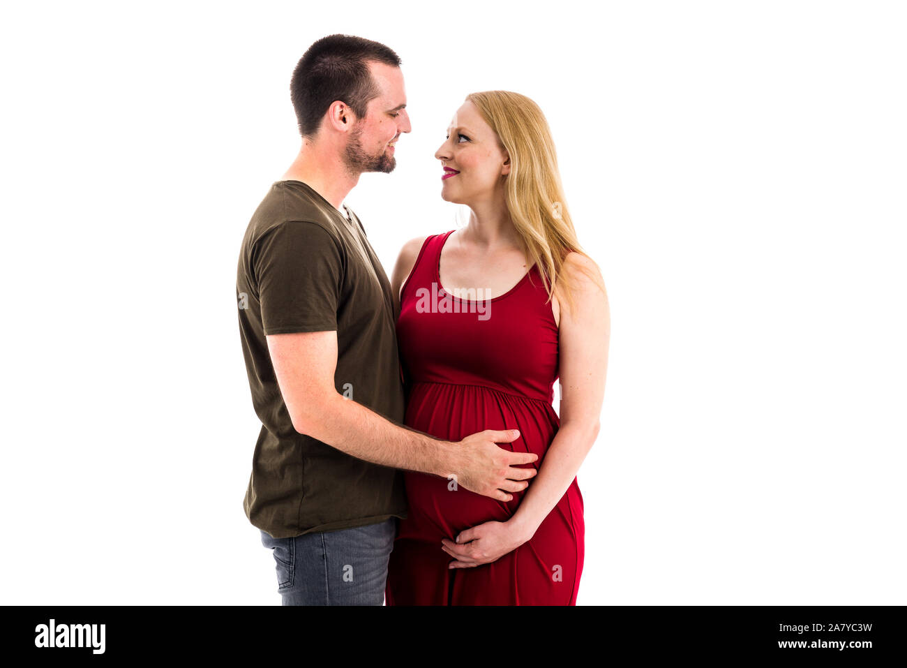 Young pregnant couple in love expecting child, studio portrait