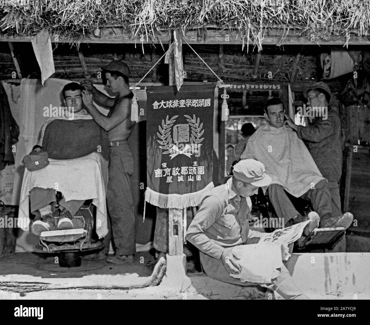 Marine corp barbers trimming hair in a former Japanese Okinawa barber shop Stock Photo