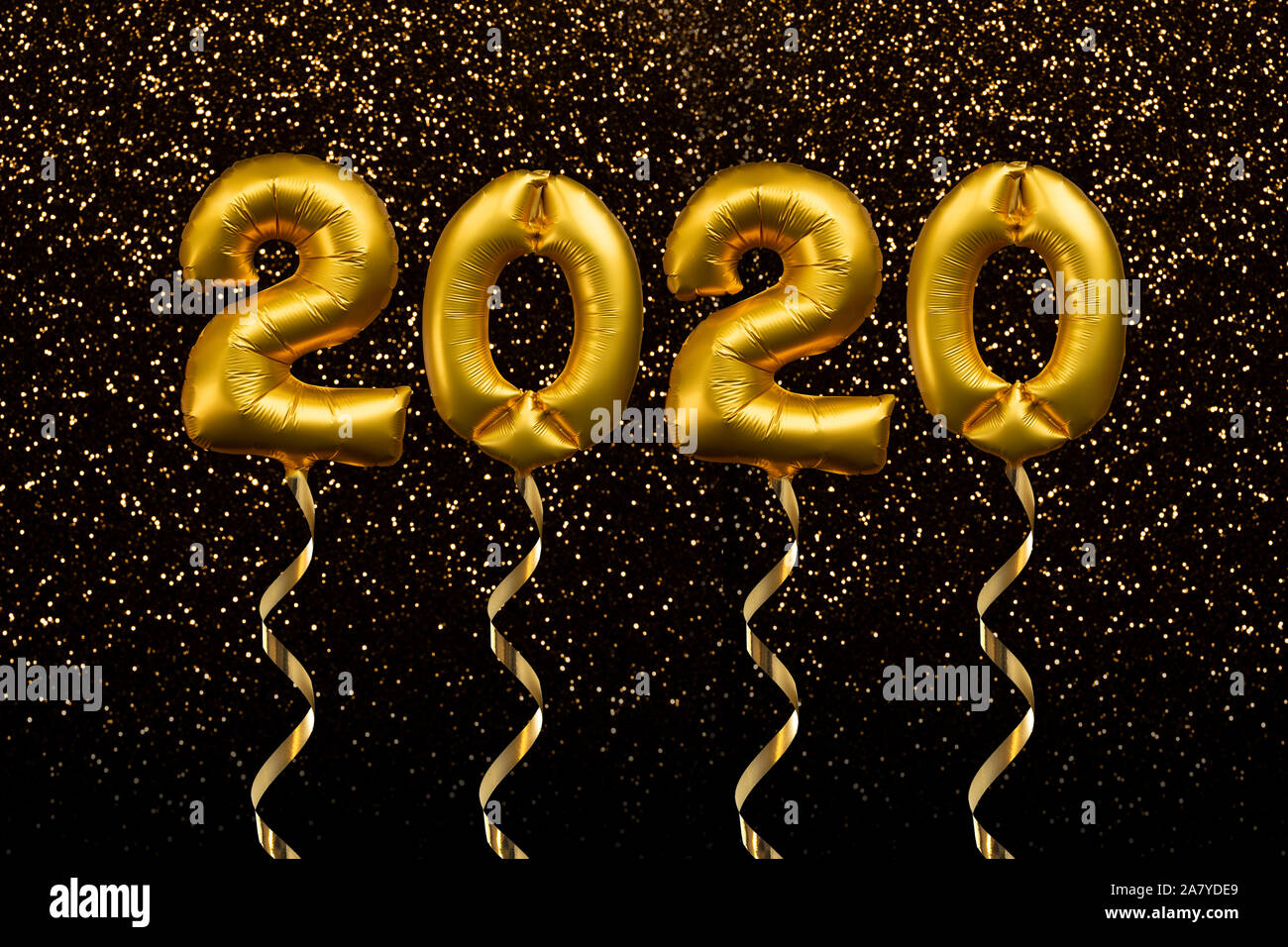 2020 written with golden balloons floating on gold glitter background, new year party greeting card Stock Photo