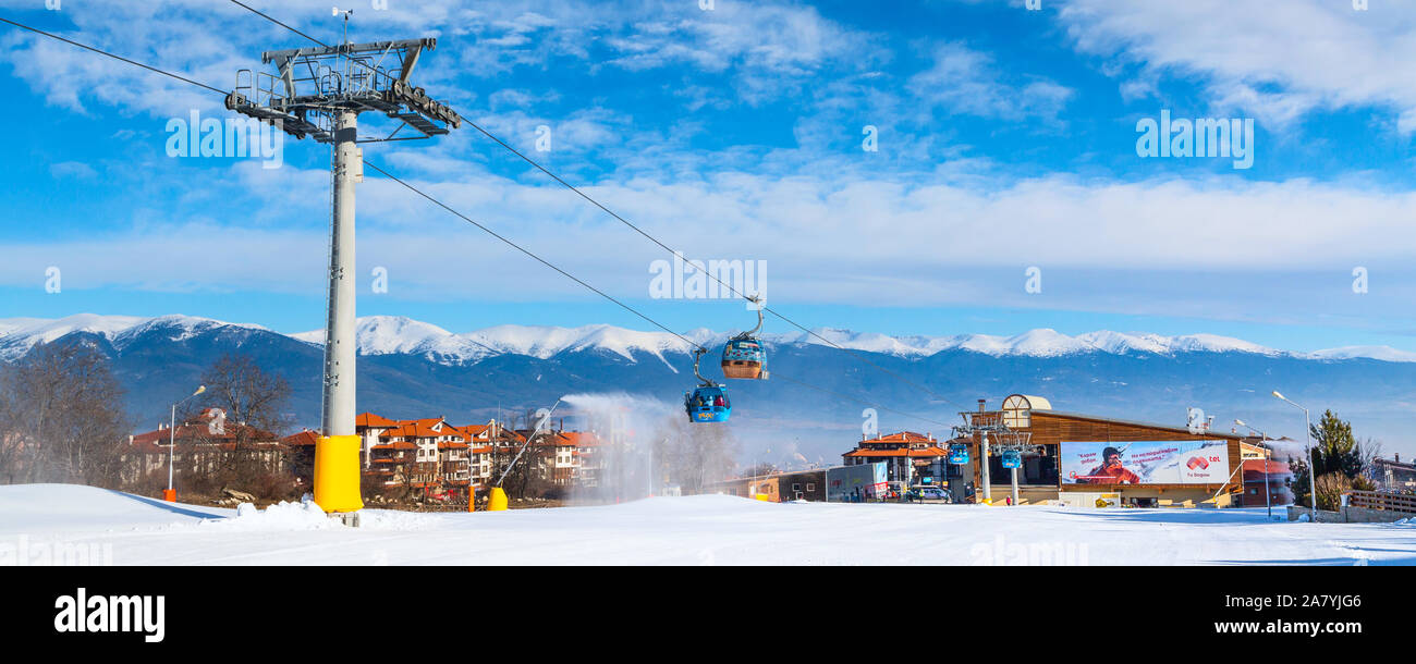 Bansko, Bulgaria - February 19, 2015: Bansko ski resort panorama with cable car ski lift cabin. Snow mountain peaks and houses Stock Photo