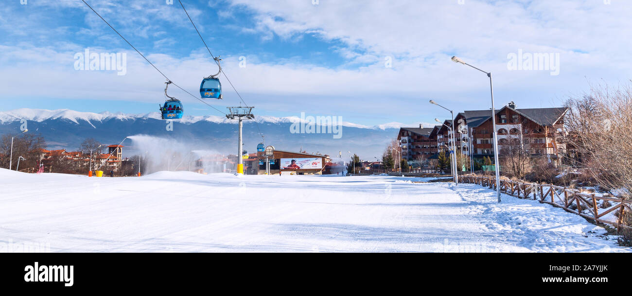 Bansko, Bulgaria - February 19, 2015: Bansko ski resort panorama with cable car ski lift cabin. Snow mountain peaks and houses Stock Photo