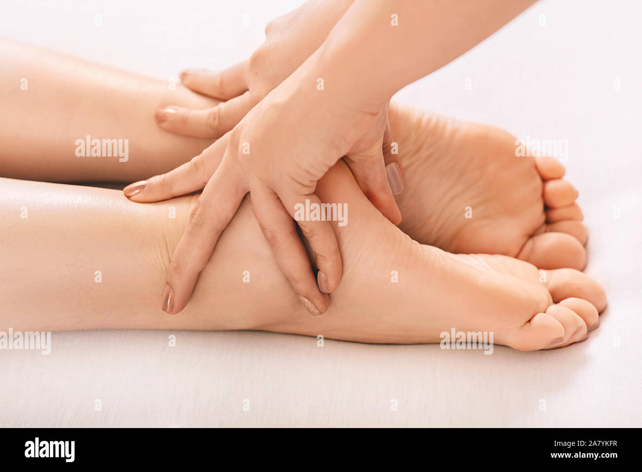 massage therapist doing wellness foot massage at spa salon, Close-up of feet. reflexology foot Stock Photo