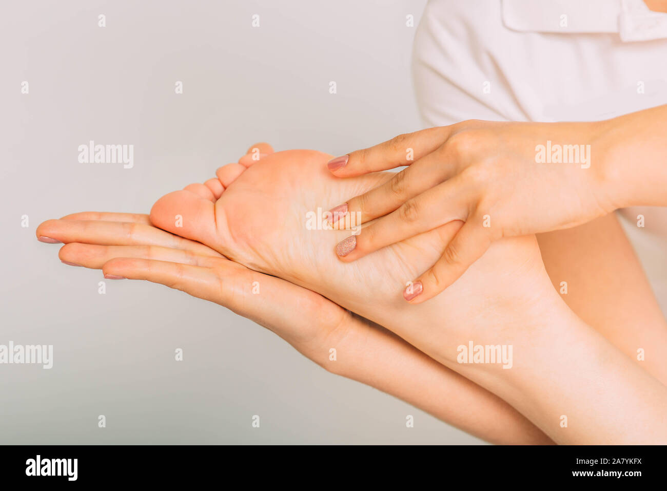 Close-up female foot while reflexology massage. Special tehnic of foot massage Stock Photo